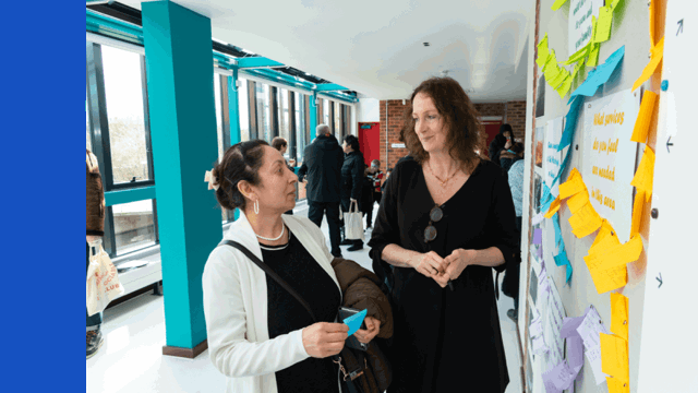 Two women standing and talking to each other