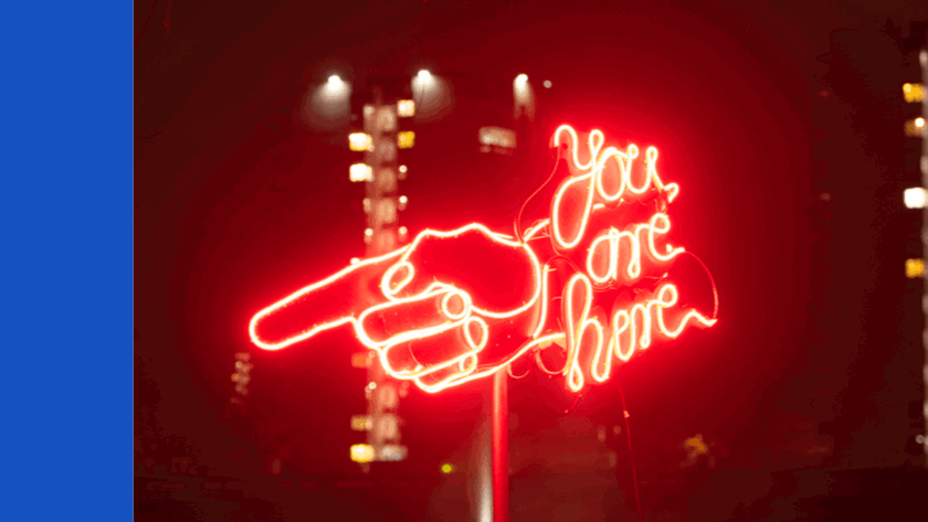 You are here text with a finger pointing in red lights