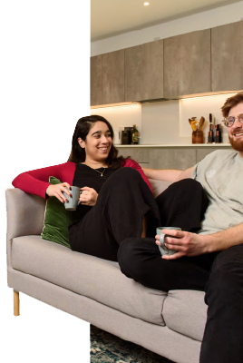 Man and woman sitting on a sofa, smiling