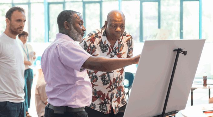 Men looking at a white board