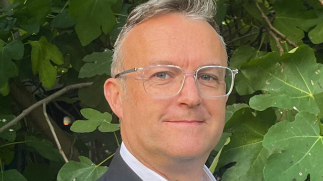 Headshot of man wearing glasses, smiling