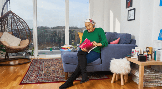Woman sitting on blue sofa, reading