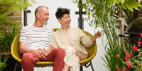 Man and woman sitting on yellow chair and smiling