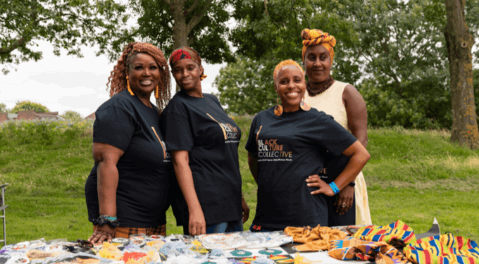 Four women standing and smiling