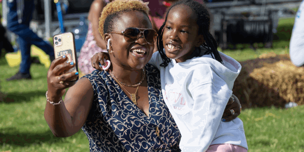 Woman and child smiling while holding a phone